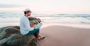 make 4-figures online offline experts online income per month man sitting on beach looking to the horizon